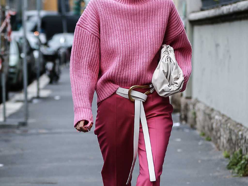 Imagem de moda streetstyle. Modelo desfila pela rua com look usando um grande cinto.