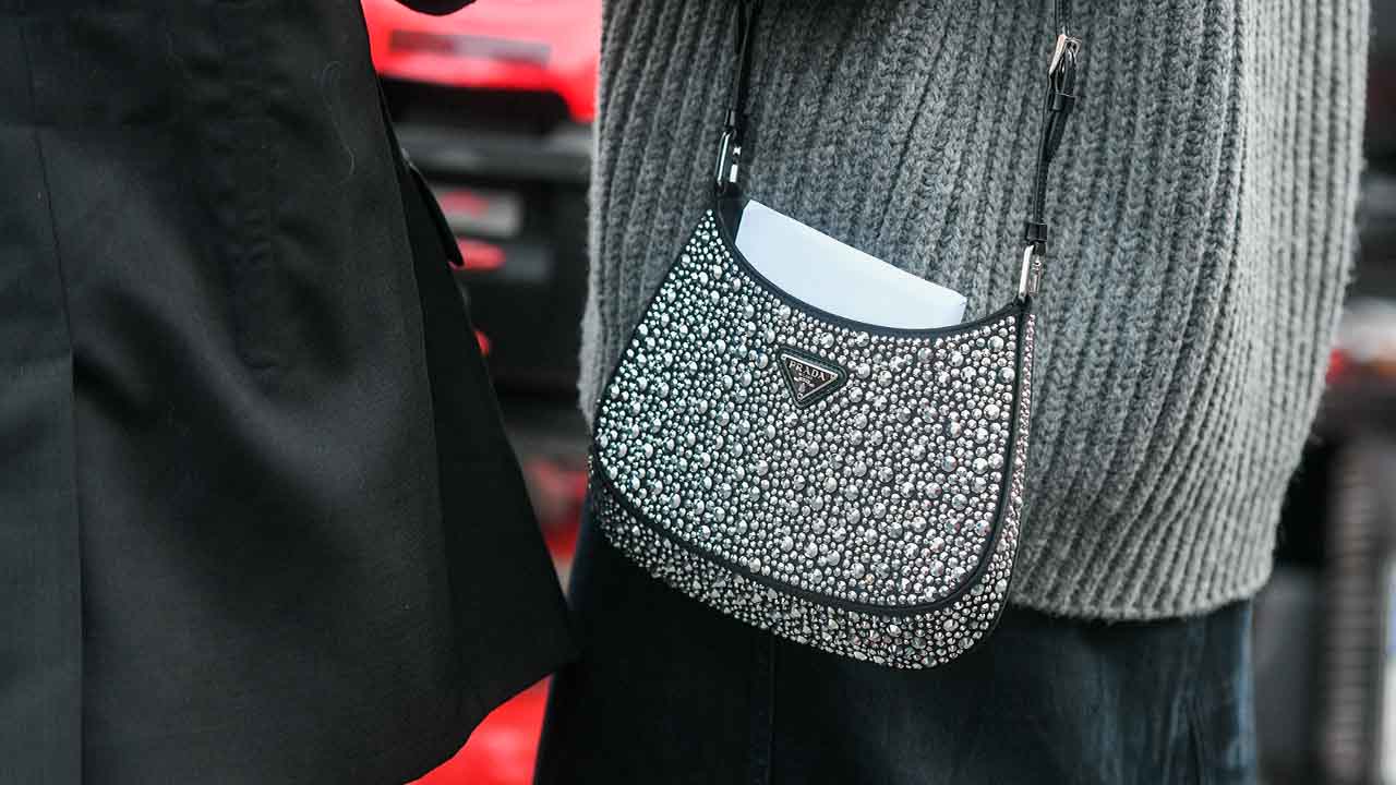 Mulher usando bolsa Prada Cleo.