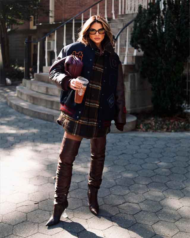 Mulher usando botas de cano alto com maxi blusa.