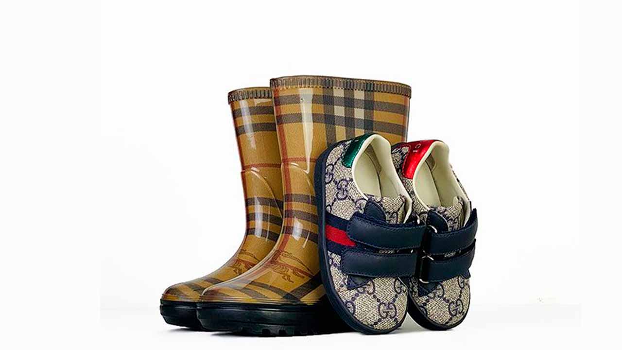 Foto d galocha e tênis das marcas que luxo que têm linha infantil: Burberry e Gucci Kids.