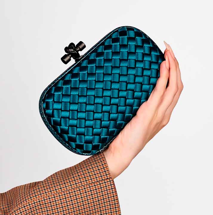 Foto segurando a clutch bottega veneta knot que está na seleção bags for party na summer sale.