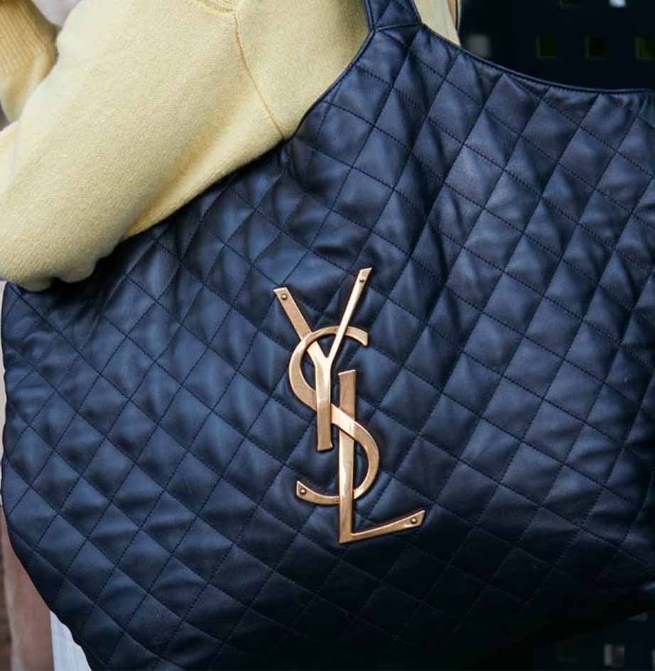Foto de estudante levando bolsa Saint Laurent embaixo do braço.