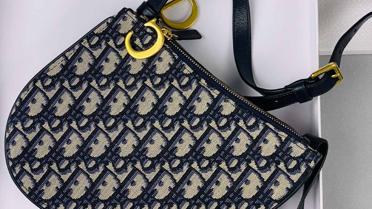 Foto de uma Bolsa Dior em cima de uma tampa.