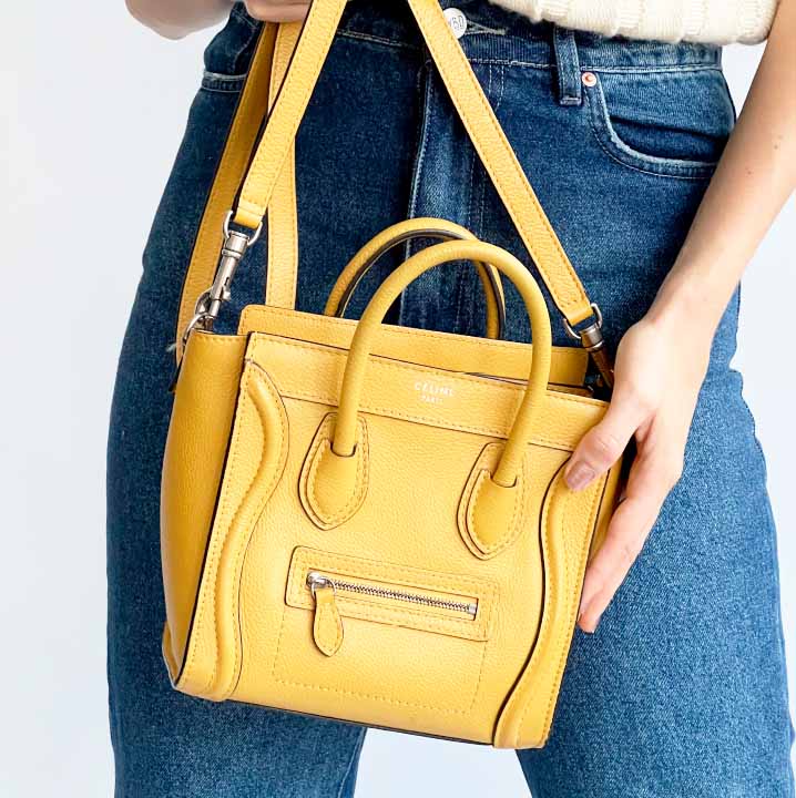 Foto de uma mulher segurando o modelo da Celine, Luggage, uma das bolsas amarelas perfeitas para os dias de calor.