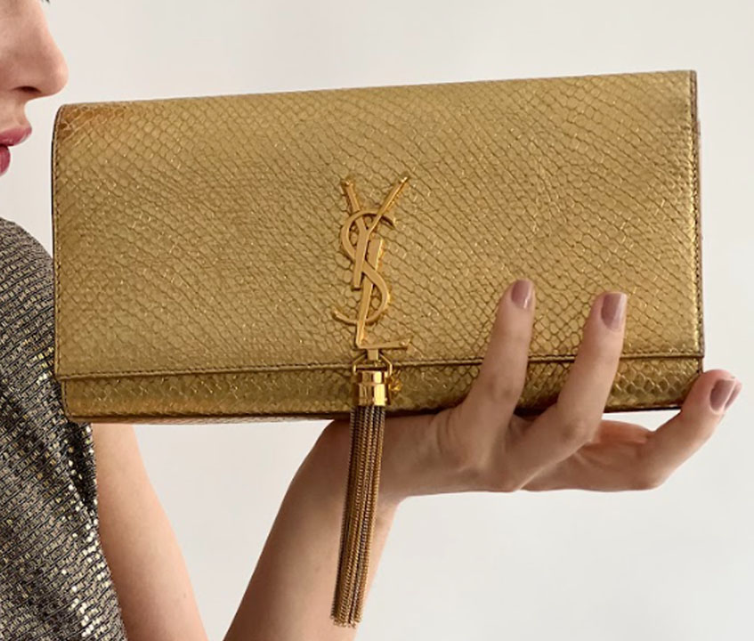 Foto de uma das bolsas douradas para réveillon de luxo da marca Yves Saint Laurent.