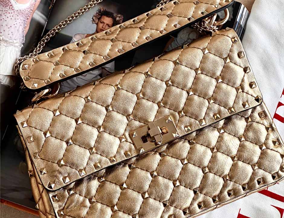 Foto de modelo de Bolsa Valentino para o Ano Novo na cor dourada que combina com réveillon.