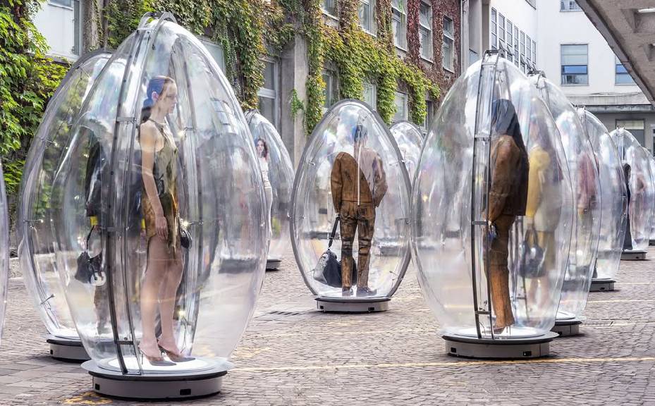 Foto da coleção diesel na semana de moda de milão verão 2026 apresentada dentro de ovos de acrílico expostos nas ruas.