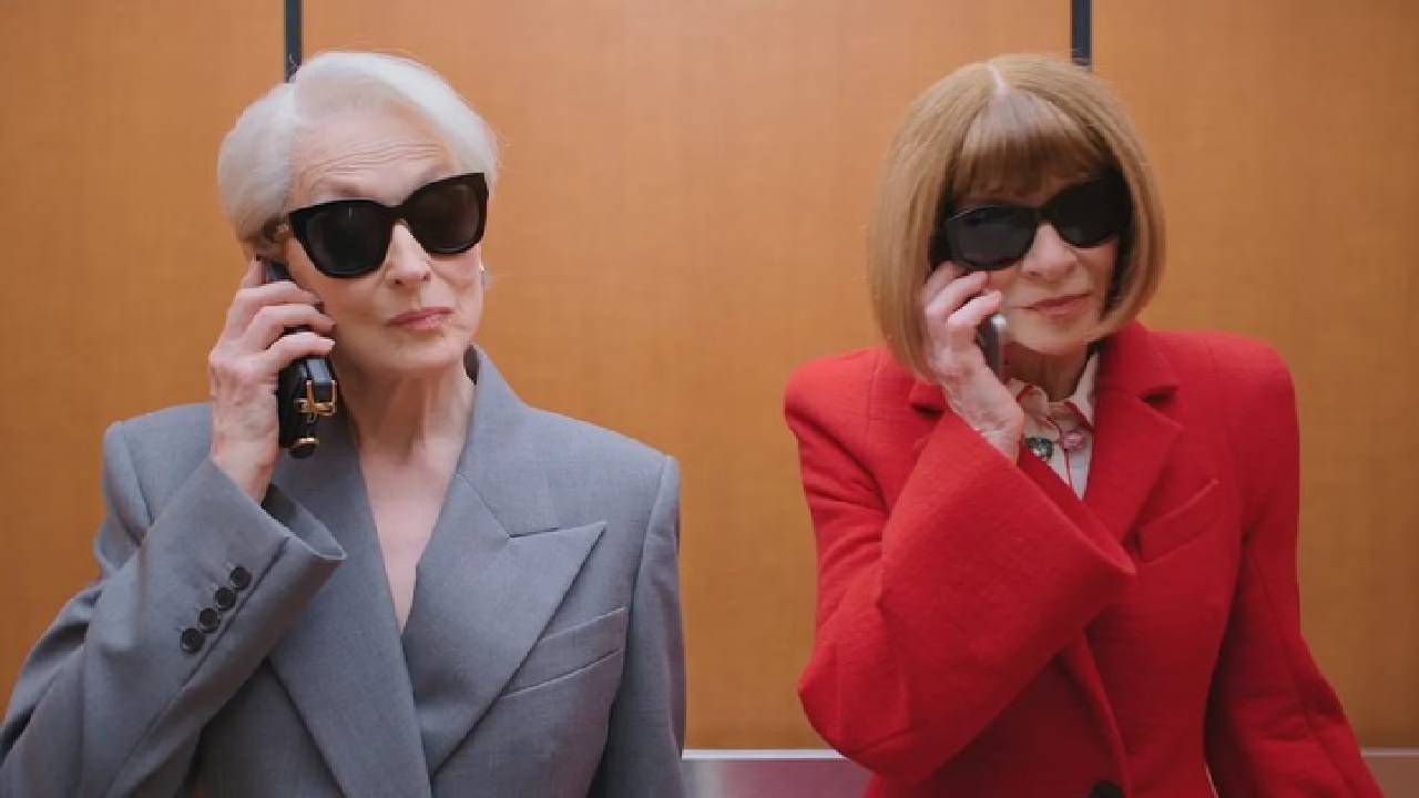 Anna Wintour ao lado de Miranda Priestly em elevador durante ensaio para a Vogue, misturando moda, cinema e universo editorial de luxo.