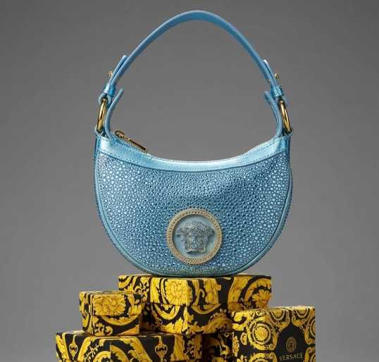 Foto da Bolsa Hobo Versace x Dua Lipa Repeat Mini com estética Y2K e design fashionista.