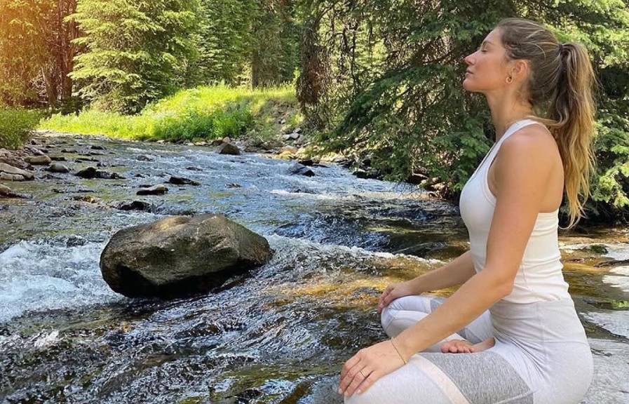 Foto de Gisele Bündchen que reforça tendência athleisure ao usar peças da Alo Yoga em sessão de meditação.