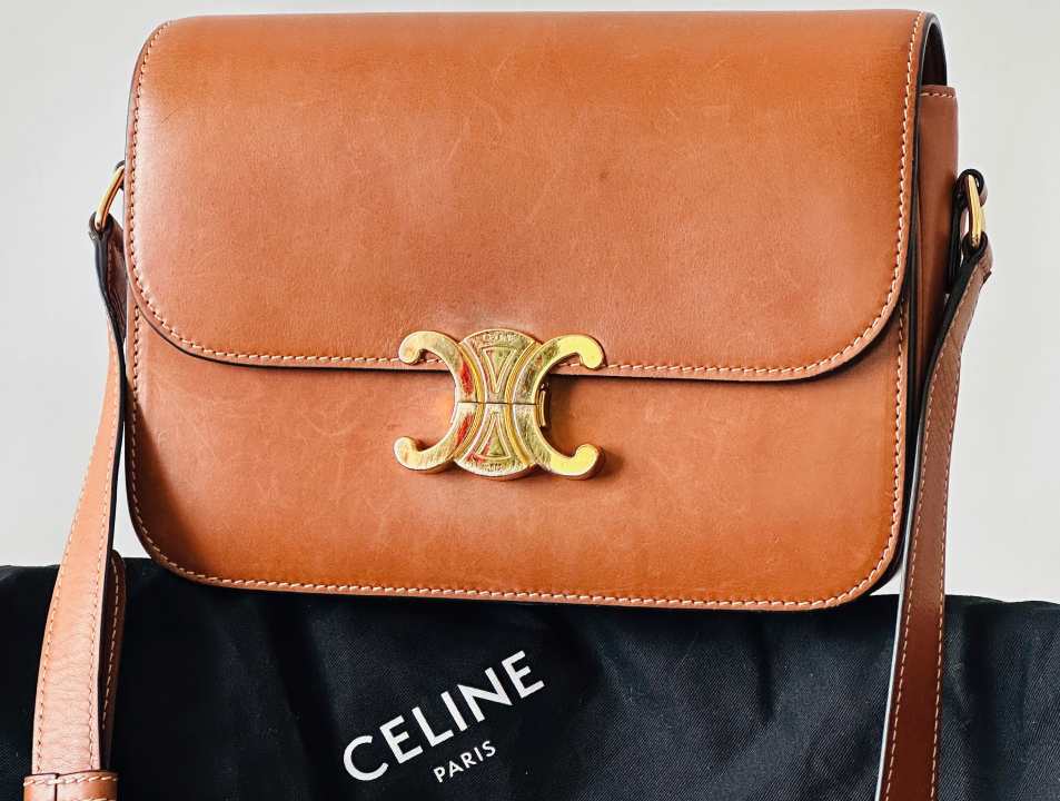 Foto de bolsa Celine Triomphe original com símbolo da marca e ferragem dourada.