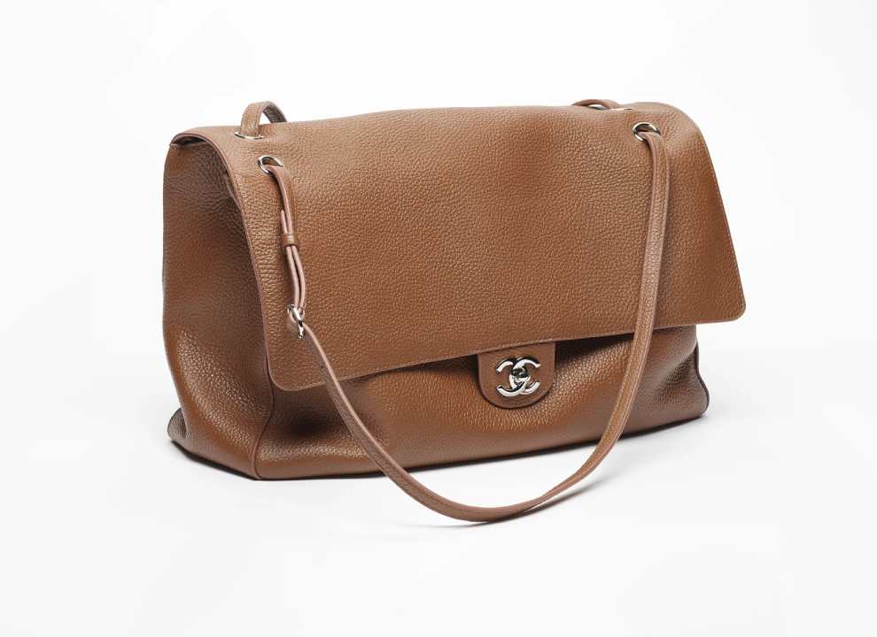 Bolsa Chanel Maxi Flap em couro mais maleável e macio, sem o típico matalessê no couro, lisa, com textura granulada.