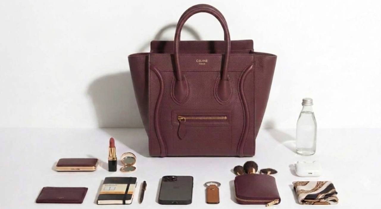 Bolsa Celine Luggage Micro acompanhada de carteira, celular, nécessaire e acessórios para ilustrar o espaço interno do modelo.